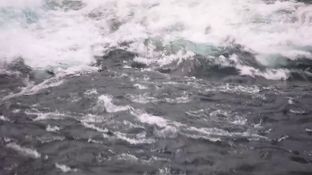 水快速下落的特写。河水的波浪、浪花和泡沫。瀑布从上面。在自然的力量。视频下载