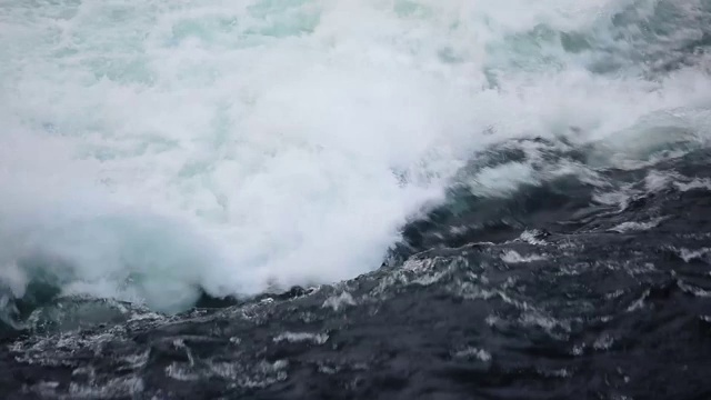 水快速下落的特写。河水的波浪、浪花和泡沫。瀑布从上面。在自然的力量。视频下载