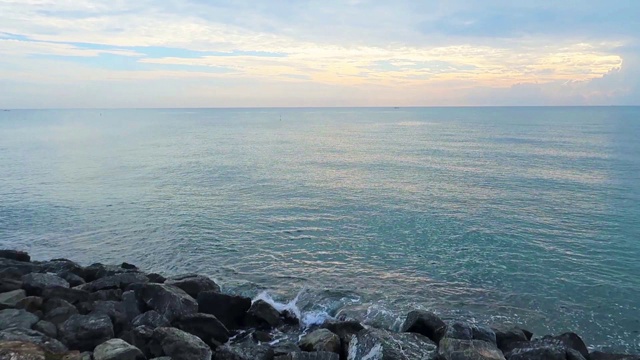 美丽的深蓝色海水海浪冲击着热带夏天的岩石海滩视频素材