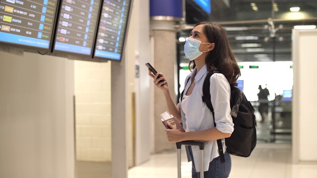 亚洲妇女戴口罩保护冠状病毒和站在飞机上:戴口罩旅行视频素材