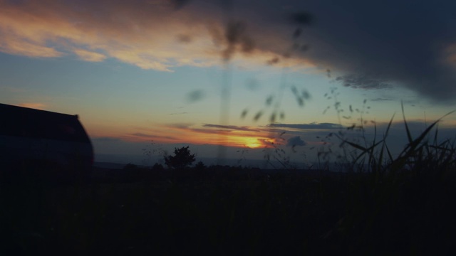 在令人惊叹的金色夕阳下，一辆SUV行驶在克里米亚山区蜿蜒的道路上。在壮丽的日落时分开车穿过群山。在荒地上的乡村吉普车视频素材