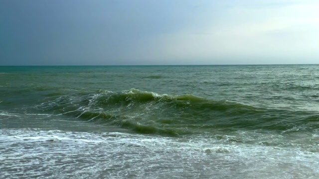 汹涌的海浪拍打着海岸线产生泡沫视频素材