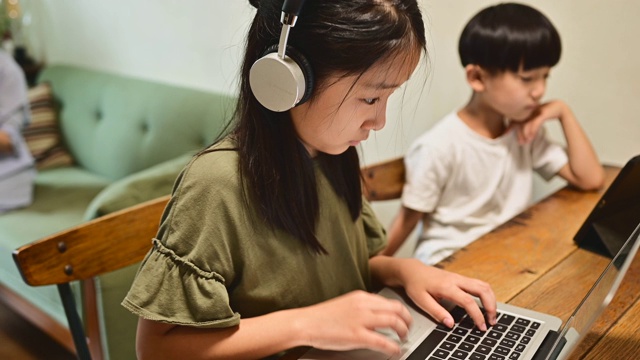 十几岁的女孩在家里的客厅学习视频在线课程。视频素材