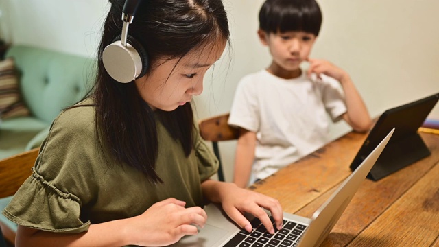 十几岁的女孩在家里的客厅学习视频在线课程。视频素材