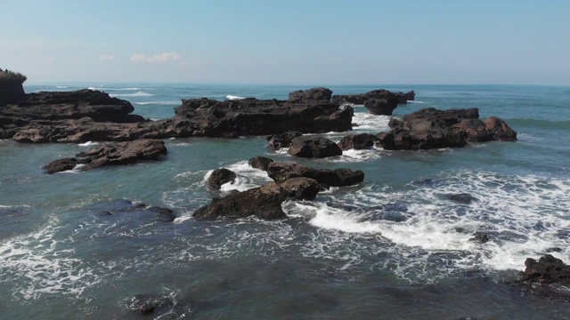 顶部鸟瞰图从飞行无人机上方的海洋景观与黑色沙滩上的大浪和岩石。复制空间为您的广告文字信息或促销内容视频素材