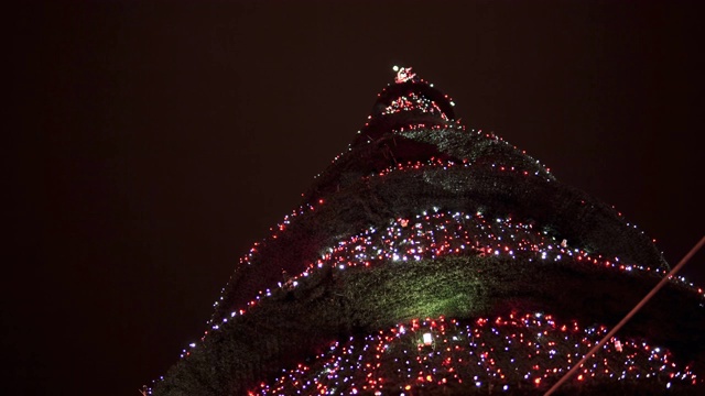 圣诞和新年的圣诞树在夜晚的灯光下以黑色为背景视频素材