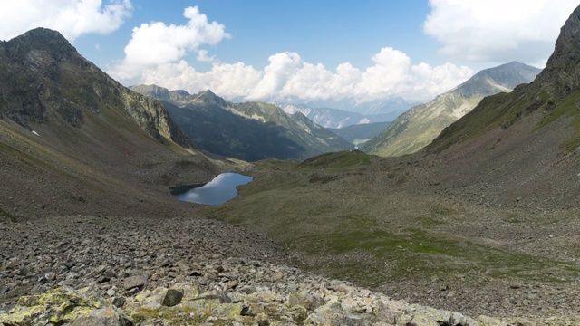 通过观看云景视图和施瓦茨莫斯湖的视图，Gossenköllesee，在冰川山Kühtai地区，著名的滑雪玩的地方，而远足，在夏季奥地利蒂罗尔徒步小径视频素材