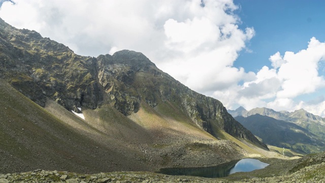 通过观看云景视图和施瓦茨莫斯湖的视图，Gossenköllesee，在冰川山Kühtai地区，著名的滑雪玩的地方，而远足，在夏季奥地利蒂罗尔徒步小径视频素材