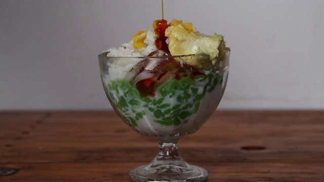 喝一种cendol dawet糯米饭，里面浸有甜的棕榈糖视频素材