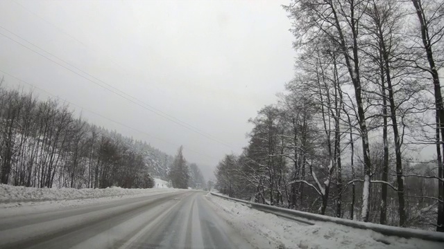 这辆车在暴风雪中行驶在冬天的路上，POV视频素材