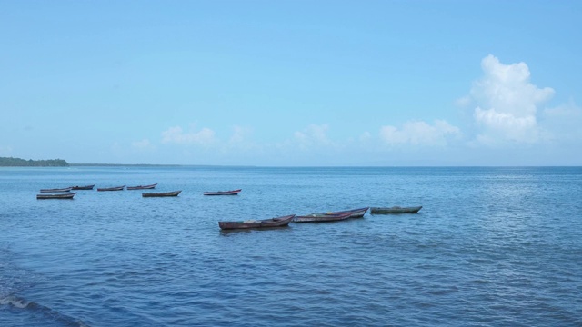 古老的木制小渔船在蓝色的海浪上平静地摇摆。视频素材