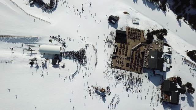 在安道尔的格兰德瓦利拉滑雪胜地沿着滑雪斜坡平稳移动的鸟瞰图。冬天的风景。山上餐厅的顶视图和滑雪缆车的长队视频素材