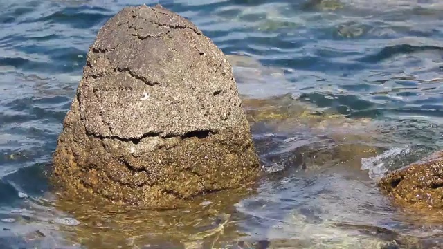 美丽的蓝色水面和岩石与移动的海浪视频下载