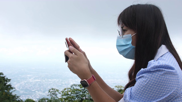 女人用智能手机拍山视频素材