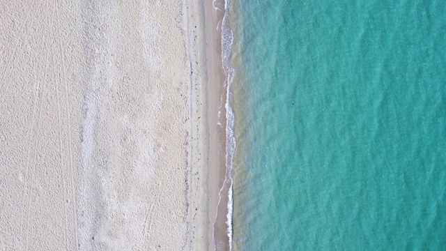 绿松石清澈的海水，溅起空旷的异国情调的海滩和白色的沙子。鸟瞰图视频素材