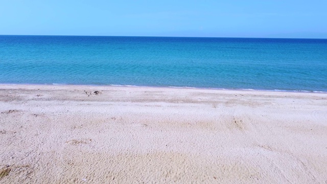 空旷的沙滩和蓝色的海水在清晨拍打着海滩。鸟瞰图视频素材