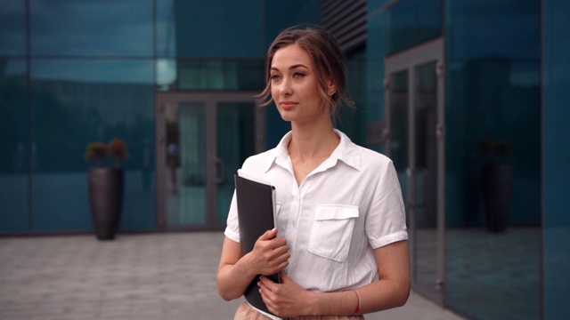 女商人成功的女商人站在户外公司大楼的外部。沉思的白人自信职业女性中年视频素材