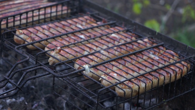 把烤架和烤香肠翻过来。美味的天然壳香肠视频素材