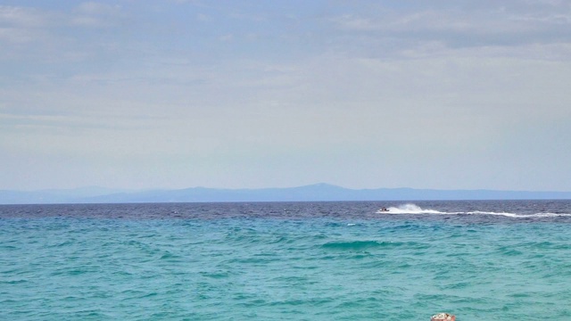 男子驾驶水上摩托艇在海平线上，夏日海滩乐趣视频素材