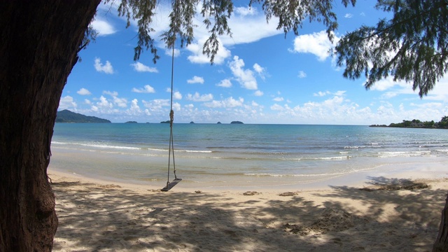 清澈的大海和白色的沙滩，以秋千和天空为背景，在泰国特拉特Koh Chang。视频素材