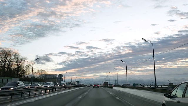 俄罗斯。透过挡风玻璃观看一辆汽车在一个有交叉路口的八车道道路上行驶，汽车在这条道路上行驶，迎面的车道上已经形成了交通堵塞。视频素材