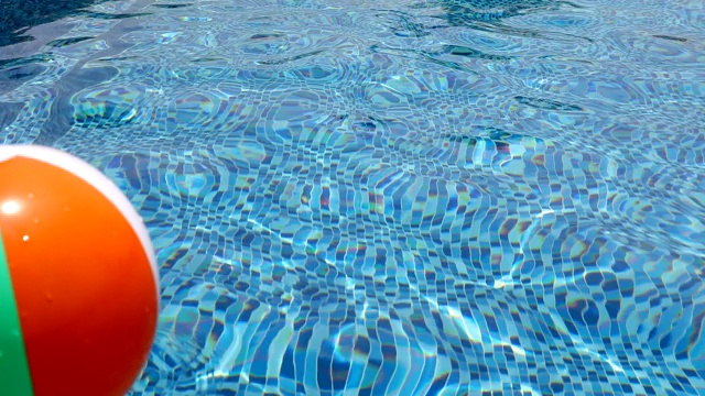 游泳池里的沙滩球。五颜六色的充气球漂浮在游泳池里，夏日概念。视频素材