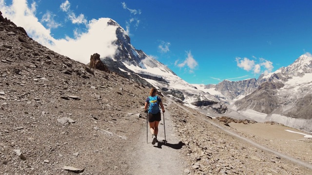 女登山运动员(从后面看)在马特洪峰景色的小径上徒步旅行视频素材