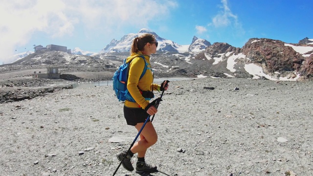 拿着登山杖在马特洪山附近的山路上行走的女人视频素材