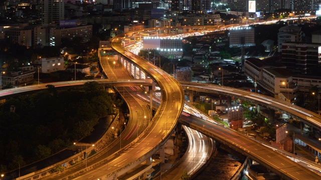 在高速公路路口行驶的汽车鸟瞰图的时间流逝。桥梁、街道、道路在建筑网络中的连接概念。前视图。曼谷夜市，泰国。视频素材