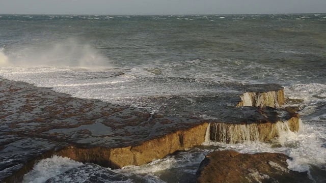 黄昏时分，海浪拍打着英格兰波特兰市陡峭的海岸线视频素材