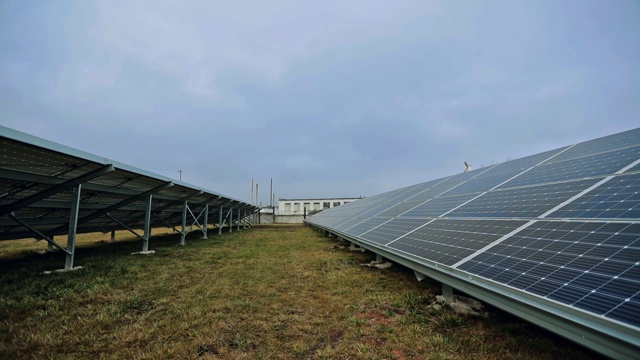 蓝天下的太阳能电池板。利用太阳能板开采电力。太阳能电池在发电站的草地上。特写镜头。视频素材