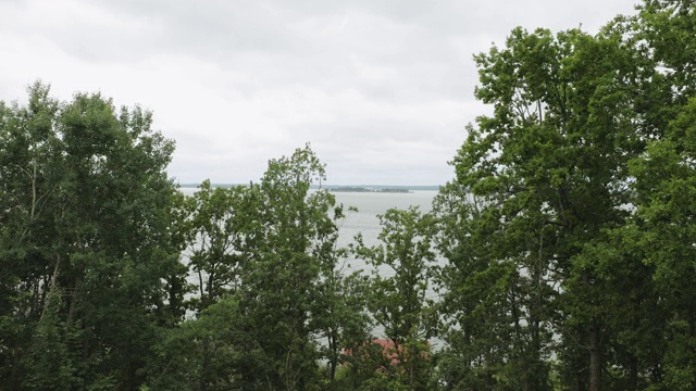 美丽的自然景观从山上通过绿树波罗的海表面在蓝天背景。视频素材