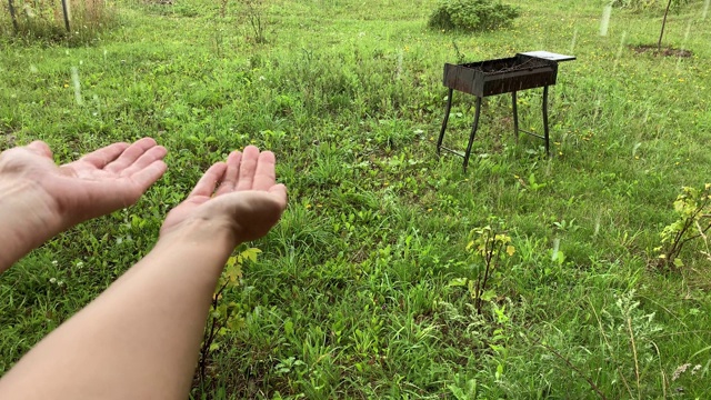 倾盆大雨，倾盆大雨，雨滴落在手上，溅起飞溅。在一个国家的夏天，下雨的夏天视频素材