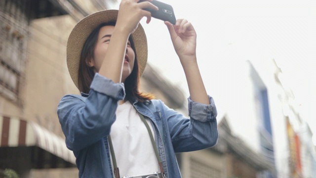 肖像美丽的潮女人戴着复古软呢帽用智能手机拍照。视频素材