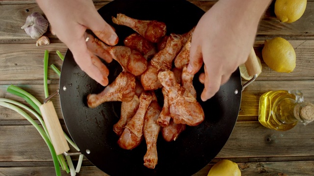 男人在烹饪前用手搅拌生鸡腿和香料。视频素材