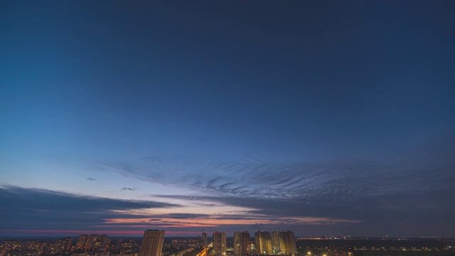 夜空的云朵掠过城市的灯光。时间流逝视频素材