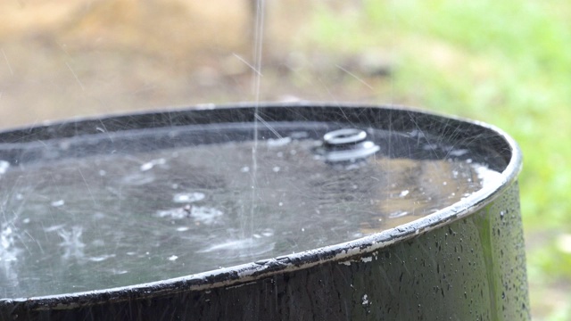 大雨落在外面的黑大桶上视频素材