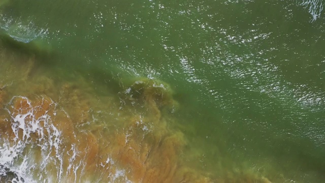 风暴期间的海浪。水在岸边翻滚沸腾，大自然的力量和美丽的粉蓝色海蓝宝石。无人机拍摄海滩波浪视频素材