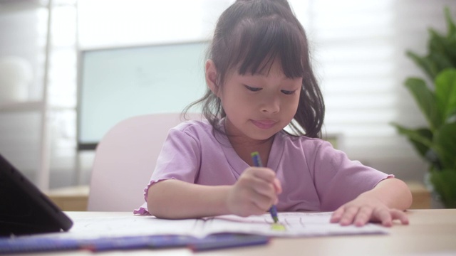 亚洲女儿在家里用数字平板电脑学习在线课程视频素材