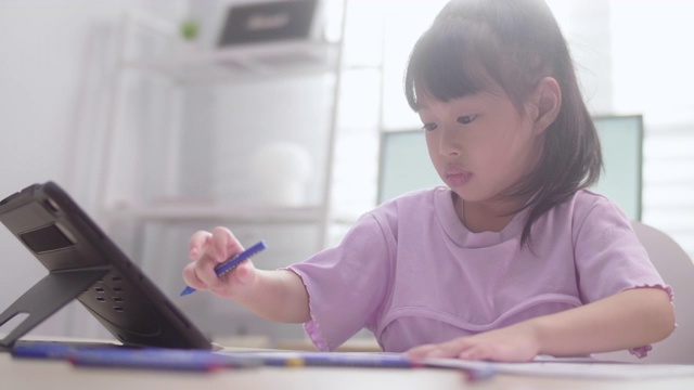 亚洲女儿在家里用数字平板电脑学习在线课程视频素材