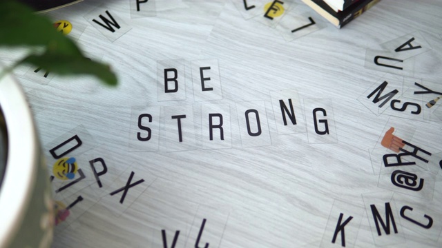 女性的手将字母组合在一起，写出了“be strong”这个词视频素材