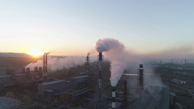 空气污染。浓烟从植物的烟囱里冒出来，在夕阳的映衬下，散发出美丽的金黄色光芒。视频素材