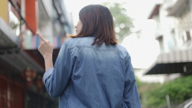 迷人的亚洲女人旅行者走在泰国曼谷的一条小街上。视频素材