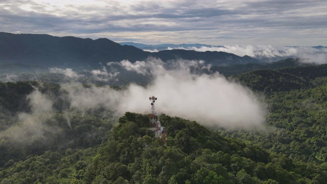 鸟瞰图，美丽的全景景观，日出在山顶与雾和温暖的光在信号中继站杆子日出，通信技术概念。湄慕兰邦，泰国。视频素材