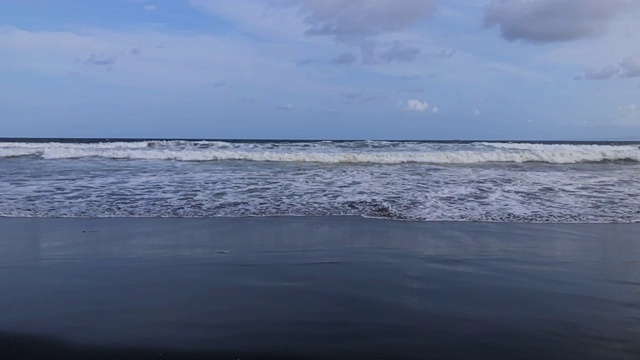 海洋/海岸上的黑砂火山海滩。视频素材