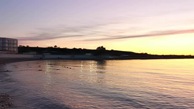 海面上橙色的夕阳，地平线上有一艘船。宁静祥和的夜景。视频素材