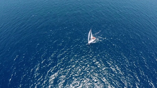 鸟瞰图，游艇沿着地中海海岸航行，在宁静、阳光明媚的蓝色海面上，视频素材