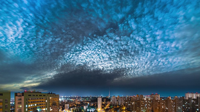 云在夜晚的大都市上空移动。时间流逝视频素材