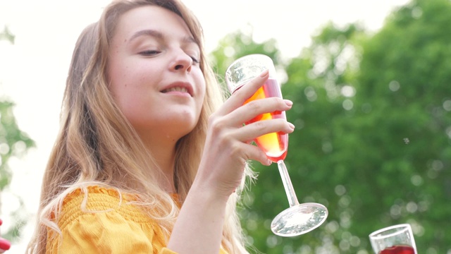 喝葡萄酒年轻女子在夏季户外聚会跳舞。女孩跳舞享受庆祝节日休闲。快乐的朋友在乡村公园野餐。夏天的假期。酒精饮料视频素材