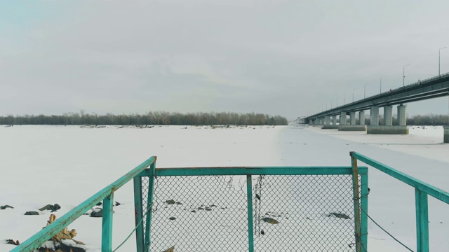 锈迹斑斑的老码头，白雪皑皑的河面上结满了冰雪视频素材